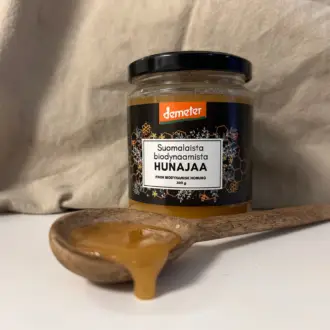 hunajapurkki, puulusikka jossa on hunajaa, pellavapyyhe, demeter, biodynaaminen hunaja, suomalainen puhdas hunaja