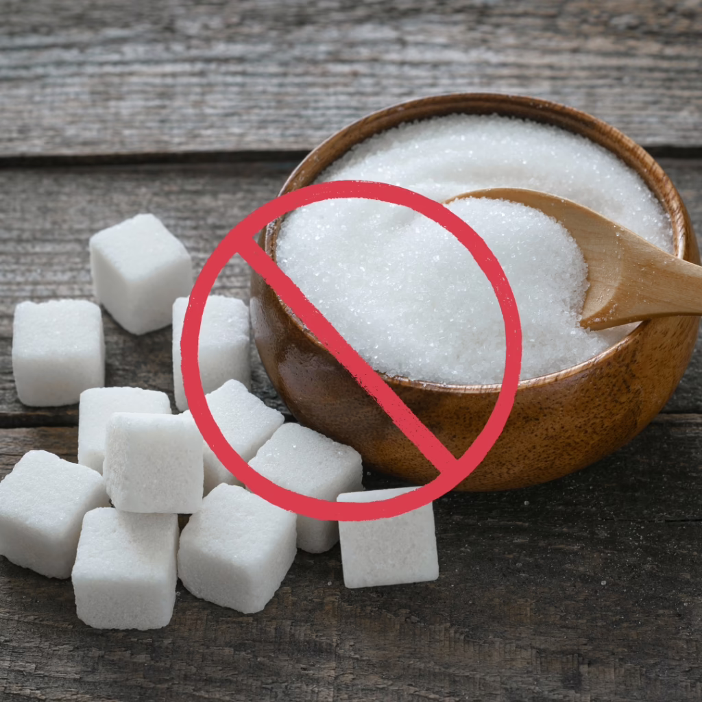 Valkosta sokeria kupissa jossa kielto merkki päällä, palasokeria pöydällä